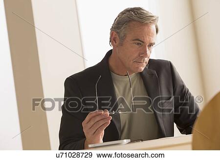 Mature business man concentrating on work View Large Photo Image Stock Photo - Mature business man concentrating on work. Fotosearch