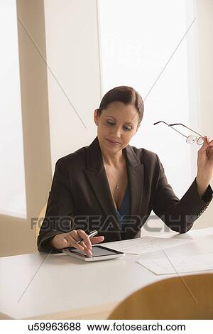 Mature business woman using digital tablet View Large Photo Image Stock Photo - Mature business woman using digital tablet. Fotosearch
