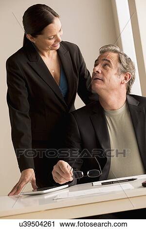 Stock Image - Mature man and woman working together. Fotosearch