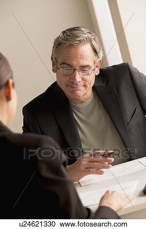 Stock Image - Mature man working with woman. Fotosearch