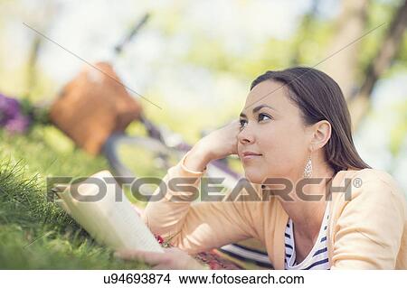 Picture - Mid adult woman reading book. Fotosearch