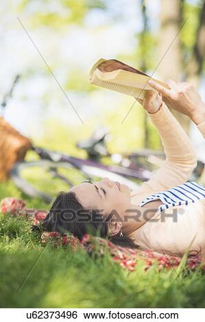 Stock Photograph - Mid adult woman reading book. Fotosearch