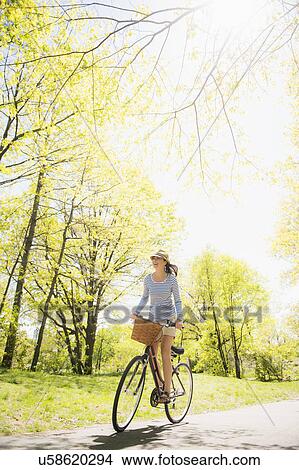 Picture - Mid adult woman riding bicycle. Fotosearch