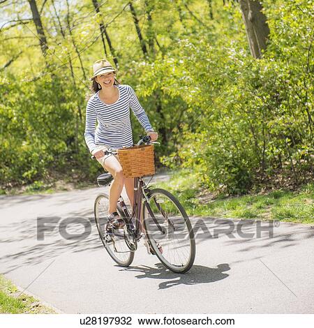 Mid adult woman riding bicycle View Large Photo Image Stock Image - Mid adult woman riding bicycle. Fotosearch