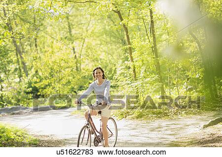 Mid adult woman riding bicycle View Large Photo Image Stock Image - Mid adult woman riding bicycle. Fotosearch