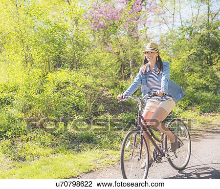 Mid adult woman riding bicycle View Large Photo Image Stock Image - Mid adult woman riding bicycle. Fotosearch