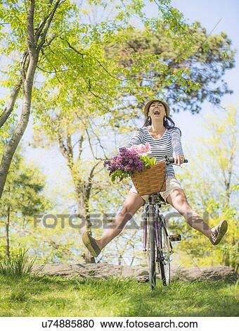 Mid adult woman riding bicycle View Large Photo Image Stock Image - Mid adult woman riding bicycle. Fotosearch