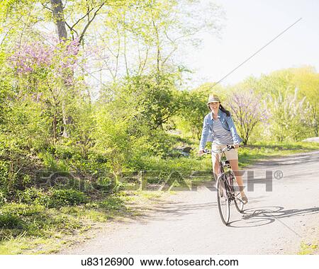 Mid adult woman riding bicycle View Large Photo Image Stock Image - Mid adult woman riding bicycle. Fotosearch