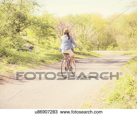 Mid adult woman riding bicycle View Large Photo Image Stock Image - Mid adult woman riding bicycle. Fotosearch