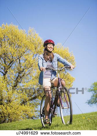 Mid adult woman riding bicycle View Large Photo Image Stock Photo - Mid adult woman riding bicycle. Fotosearch