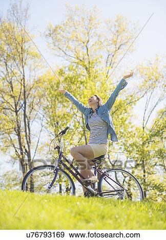 Mid adult woman riding bicycle View Large Photo Image Stock Photo - Mid adult woman riding bicycle. Fotosearch