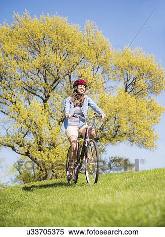 Mid adult woman riding bicycle View Large Photo Image Stock Photography - Mid adult woman riding bicycle. Fotosearch