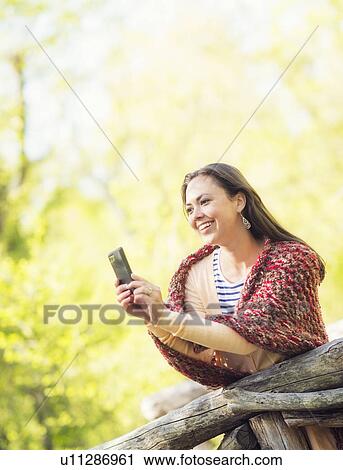 Mid adult woman using mobile phone View Large Photo Image Stock Image - Mid adult woman using mobile phone. Fotosearch