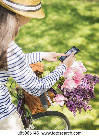 Stock Photograph - Mid adult woman using mobile phone. Fotosearch