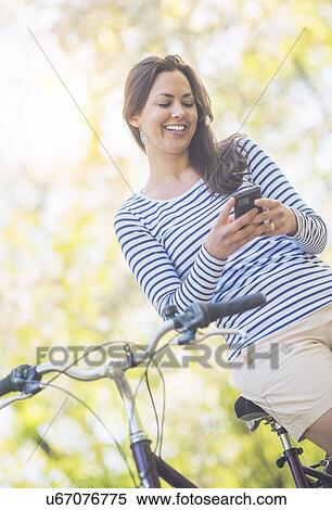 Stock Photography - Mid adult woman using mobile phone. Fotosearch
