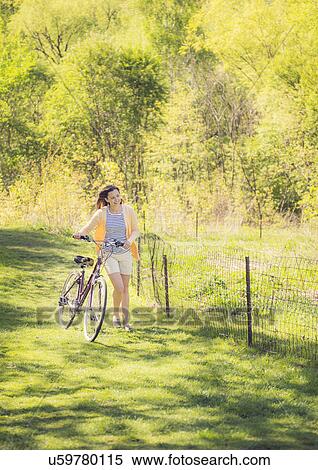 Stock Photography - Mid adult woman with bicycle. Fotosearch