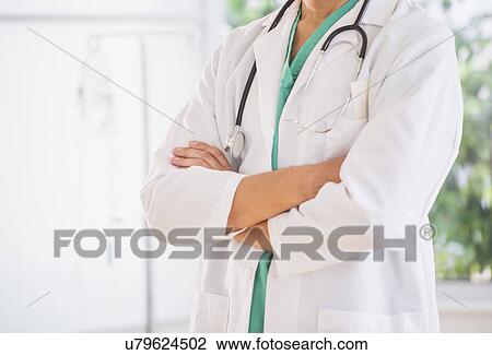 Stock Image - Mid section of doctor with arms crossed and stethoscope . Fotosearch