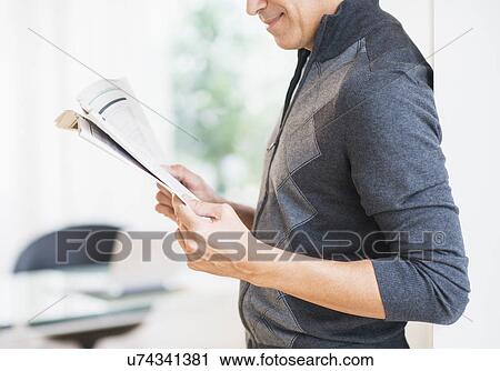 Mid section of man holding newspaper View Large Photo Image Stock Image - Mid section of man holding newspaper . Fotosearch
