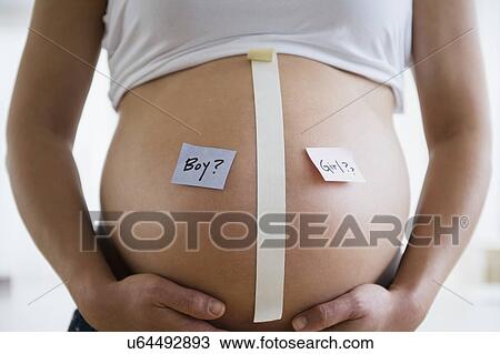 Stock Image - Mid section of pregnant woman with name tags on belly. Fotosearch