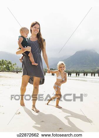 Mother walking with daughters (6-11 months, 2-3) on beach View Large Photo Image Stock Image - Mother walking with daughters (6-11 months, 2-3) on beach. Fotosearch
