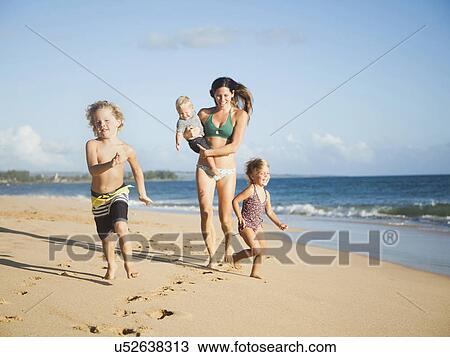 Stock Image - Mother with children on beach. Fotosearch