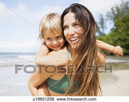 Stock Photo - Mother with daughter (2-3) on beach. Fotosearch