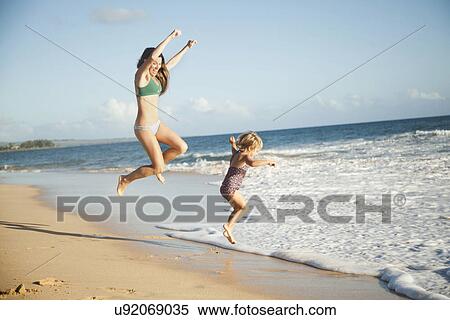 Stock Photography - Mother with daughter (2-3) playing on beach. Fotosearch