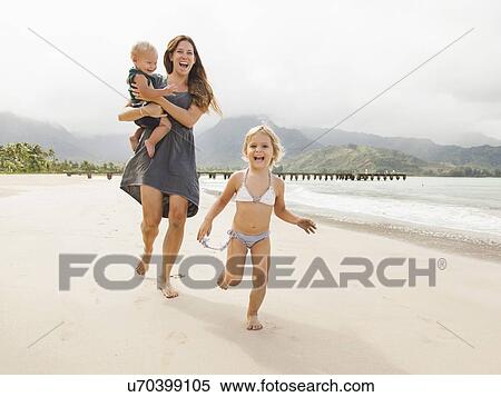 Mother with daughters (6-11 months, 2-3) on beach View Large Photo Image Stock Photography - Mother with daughters (6-11 months, 2-3) on beach. Fotosearch