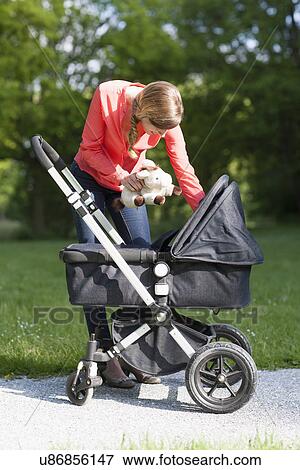 Mother with pram in park View Large Photo Image Stock Photo - Mother with pram in park. Fotosearch