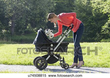 Stock Photography - Mother with pram in park. Fotosearch