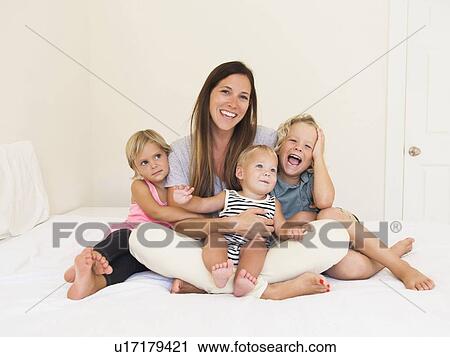 Stock Image - Mother with three kids (6-7, 2-3, 6-11 months). Fotosearch