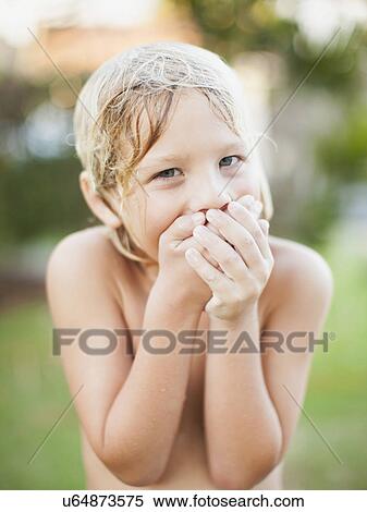 Stock Photography - Portrait of boy (8-9) with hands covering mouth. Fotosearch