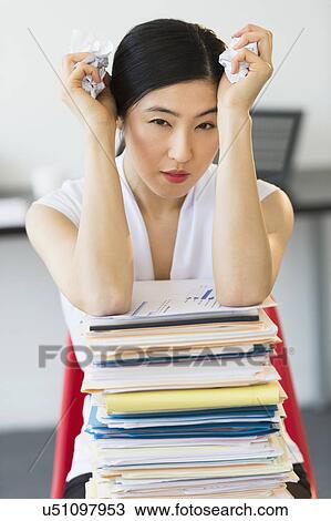 Stock Image - Portrait of businesswoman with stack of files. Fotosearch