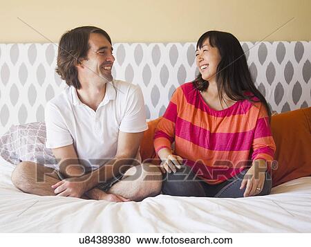 Portrait of couple sitting on bed View Large Photo Image Stock Image - Portrait of couple sitting on bed. Fotosearch