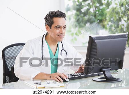 Stock Image - Portrait of doctor working in office. Fotosearch