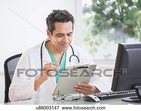 Stock Photo - Portrait of doctor working in office. Fotosearch