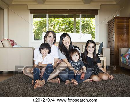 Picture - Portrait of family sitting in living room. Fotosearch