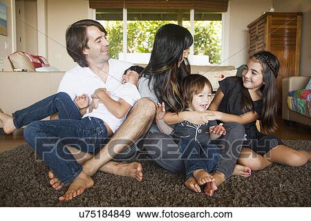 Portrait of family sitting in living room View Large Photo Image Stock Photo - Portrait of family sitting in living room. Fotosearch
