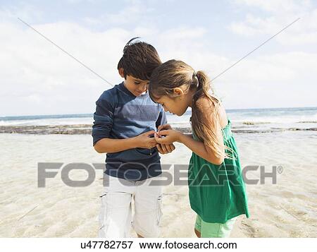 Portrait of girl (6-7) and boy (10-11) on beach View Large Photo Image Stock Photo - Portrait of girl (6-7) and boy (10-11) on beach. Fotosearch