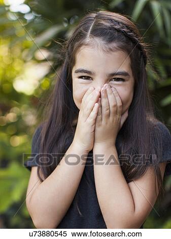 Stock Photography - Portrait of girl (8-9) covering mouth. Fotosearch