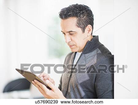 Portrait of man holding digital tablet View Large Photo Image Stock Photo - Portrait of man holding digital tablet. Fotosearch