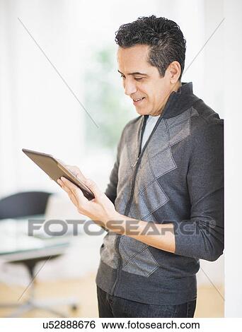 Portrait of man holding digital tablet View Large Photo Image Stock Photograph - Portrait of man holding digital tablet. Fotosearch