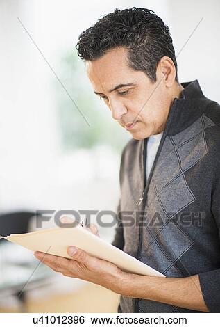 Portrait of man holding documents and writing View Large Photo Image Stock Photograph - Portrait of man holding documents and writing. Fotosearch