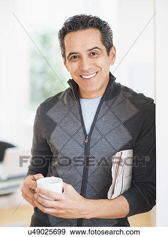 Stock Photo - Portrait of man holding newspaper and coffee mug. Fotosearch