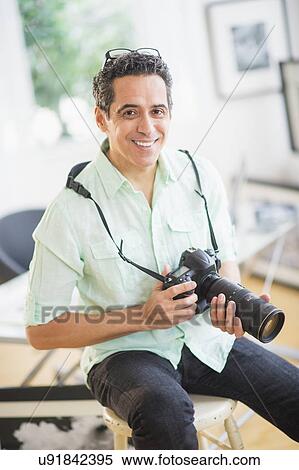Portrait of man holding photo camera View Large Photo Image Stock Photography - Portrait of man holding photo camera. Fotosearch