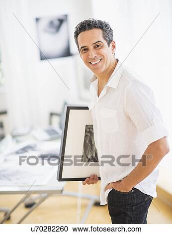 Stock Image - Portrait of man in his photography studio. Fotosearch