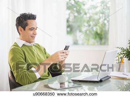 Portrait of man using mobile phone at desk View Large Photo Image Stock Image - Portrait of man using mobile phone at desk. Fotosearch