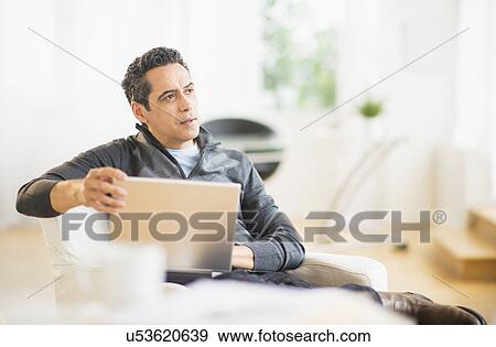 Portrait of man working on laptop at home View Large Photo Image Stock Photo - Portrait of man working on laptop at home. Fotosearch