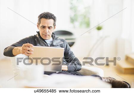 Portrait of man working on laptop at home View Large Photo Image Stock Photography - Portrait of man working on laptop at home. Fotosearch