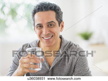Portrait of mature man holding glass of water View Large Photo Image Stock Image - Portrait of mature man holding glass of water. Fotosearch